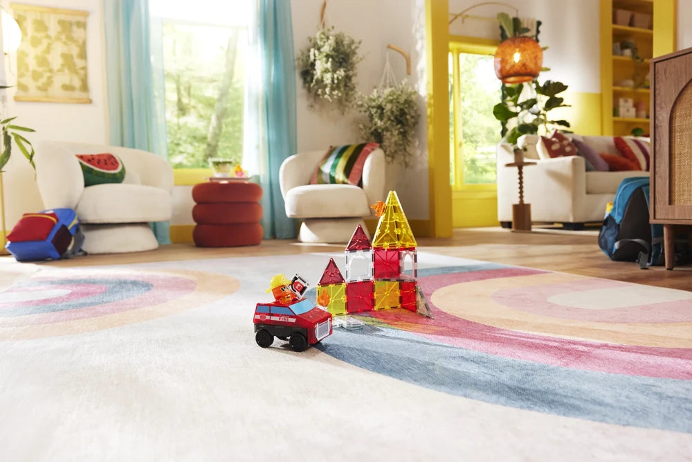 Brandweerauto en Fire Station gemaakt van magnetische Magna Tiles in een kleurrijke, gezellige kinderkamer.