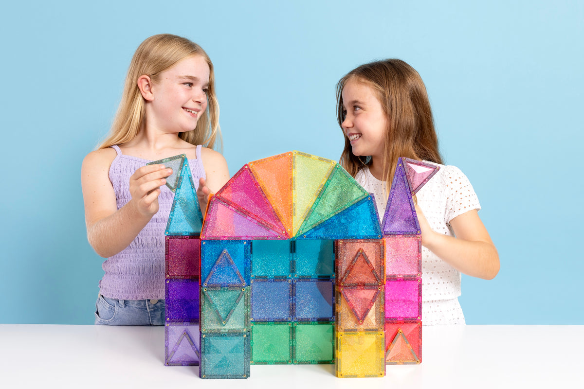 Twee meisjes bouwen samen een kasteel met de Connetix Glitter Castle Pack 48pc magnetisch speelgoed