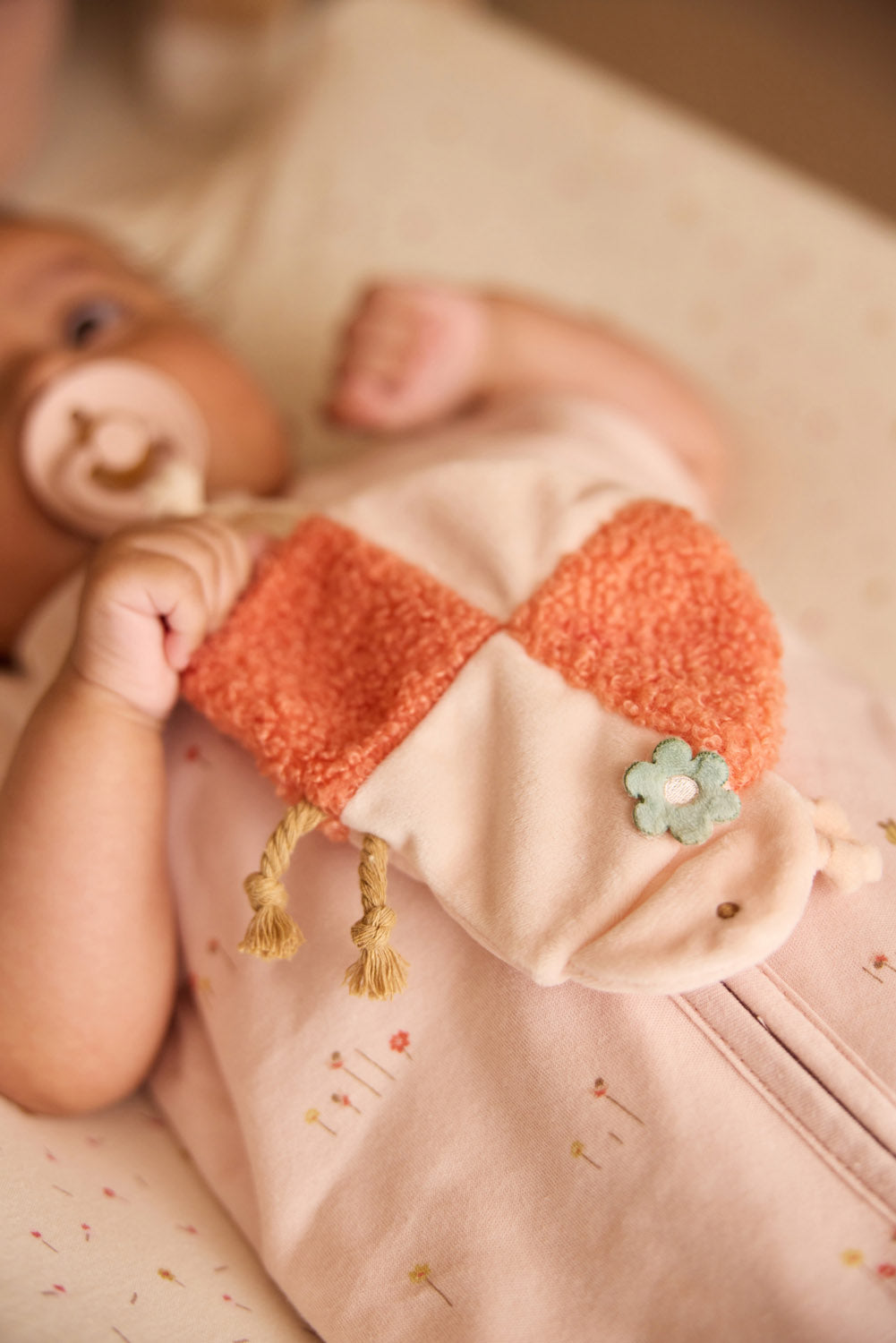 Jollein speendoekje ladybug lieveheersbeestje in handen van baby, oranje teddy en beige velvet, detail foto