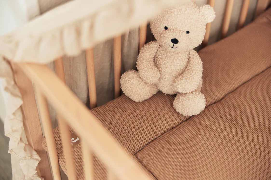 Naturelkleurige Jollein teddybeer in houten ledikant met beige beddengoed, zachte dikke knuffel voor baby’s.