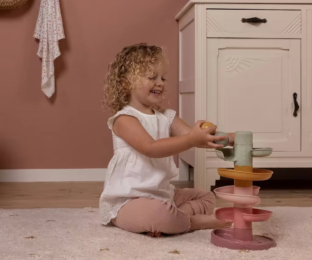 Peuter speelt lachend met de Little Dutch Spiraaltoren Roze, montessori speelgoed dat zorgt voor leerzaam speelplezier.