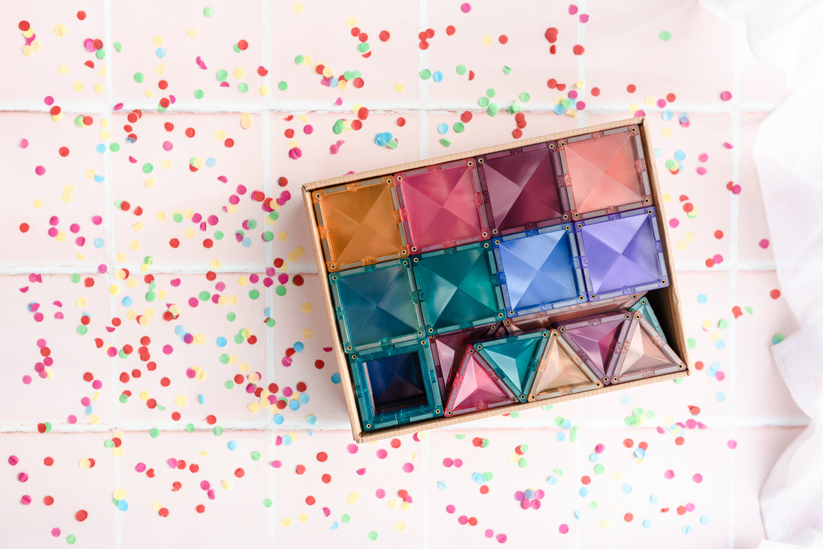 Bovenaanzicht open doos Connetix Pastel Creative Pack 120pc met kleurrijke magneet tegels op confetti