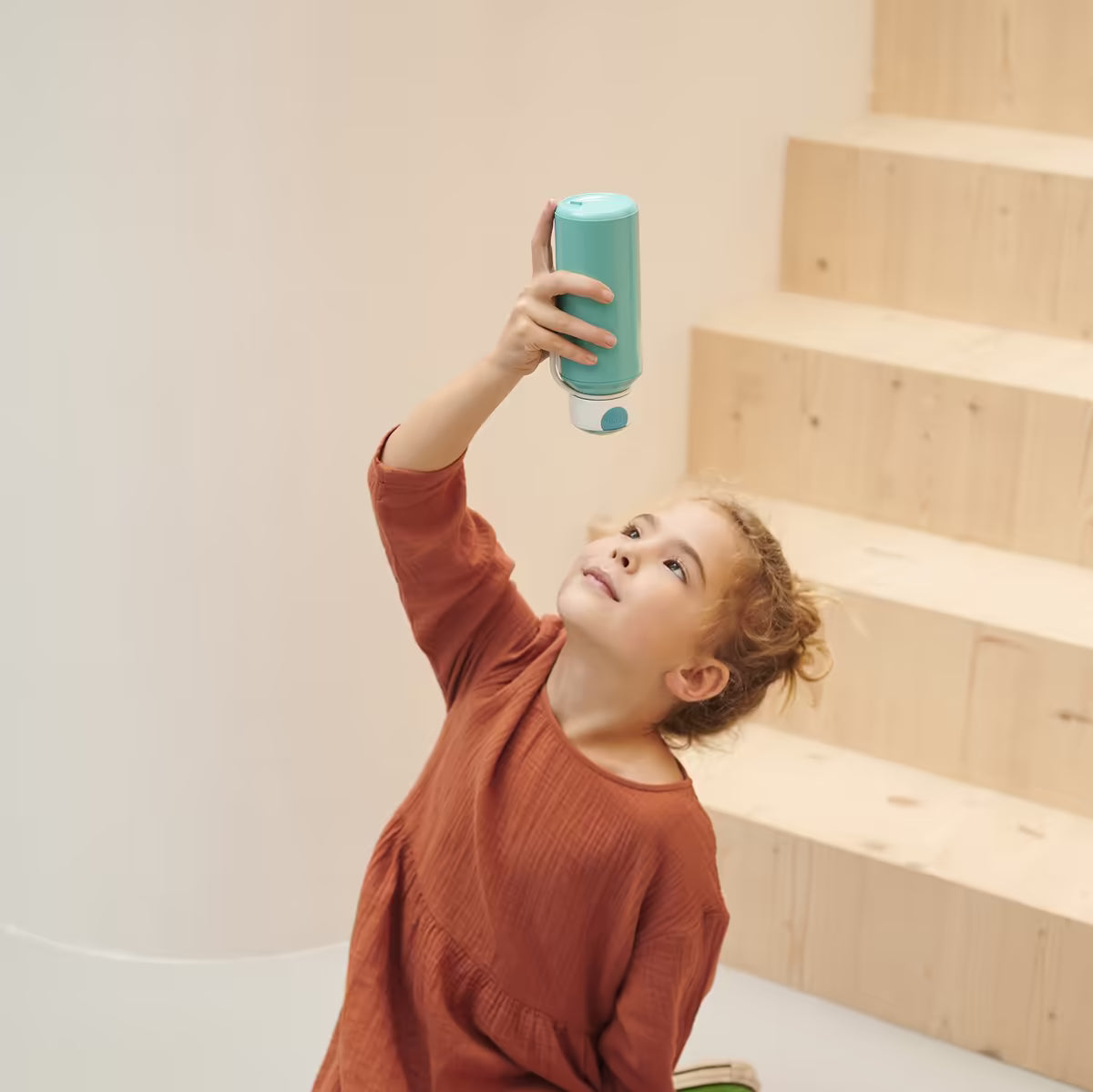 Kind tilt turquoise Mepal drinkbeker omhoog, kindvriendelijk en lekvrij ontwerp, ideaal voor dagelijks gebruik op school