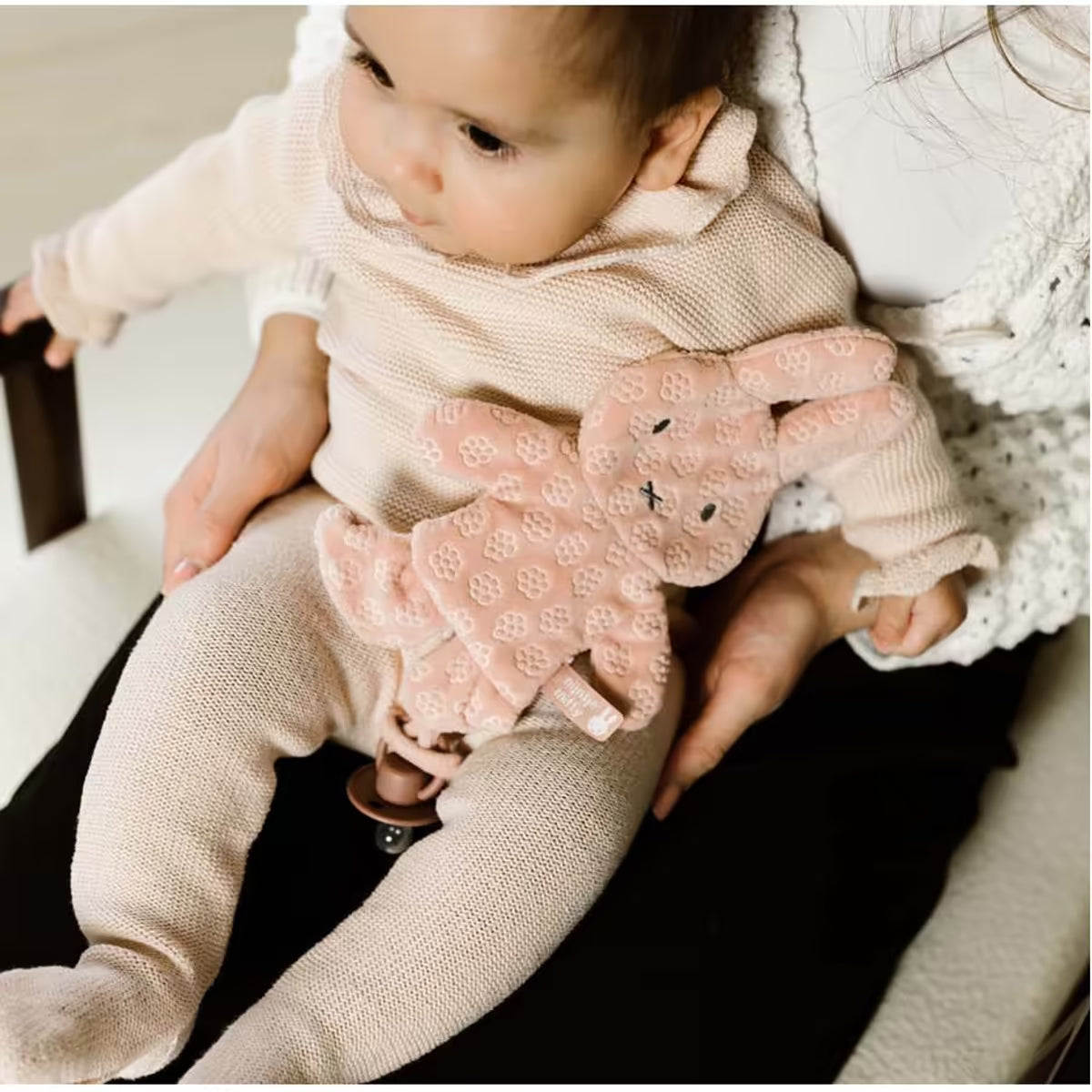 Baby op schoot met Nijntje Speendoekje Pink Flower, zacht speenknuffel en knuffeldoekje in roze bloemenmotief.
