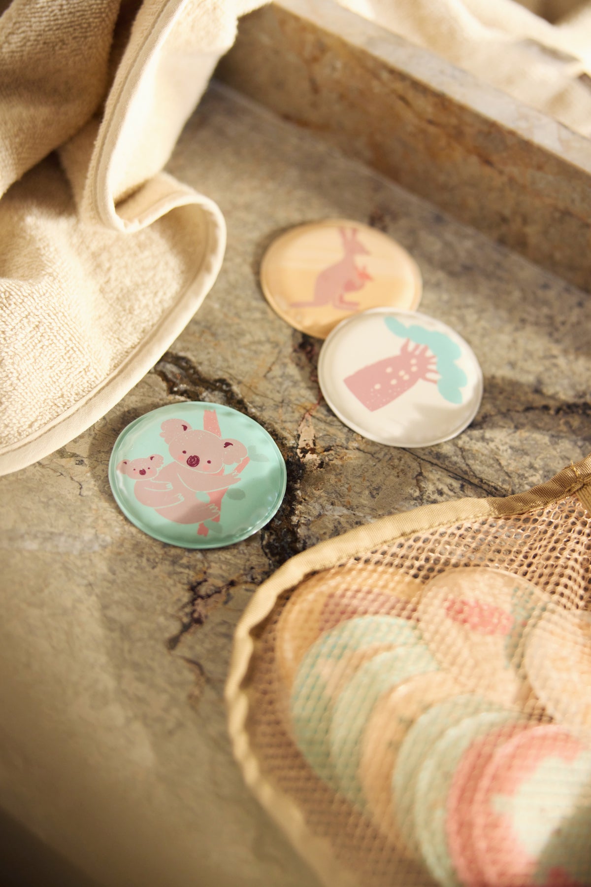 Opbergen badspeelgoed detail met Jollein Kangaroots memoryschijfjes en crèmekleurig washandje