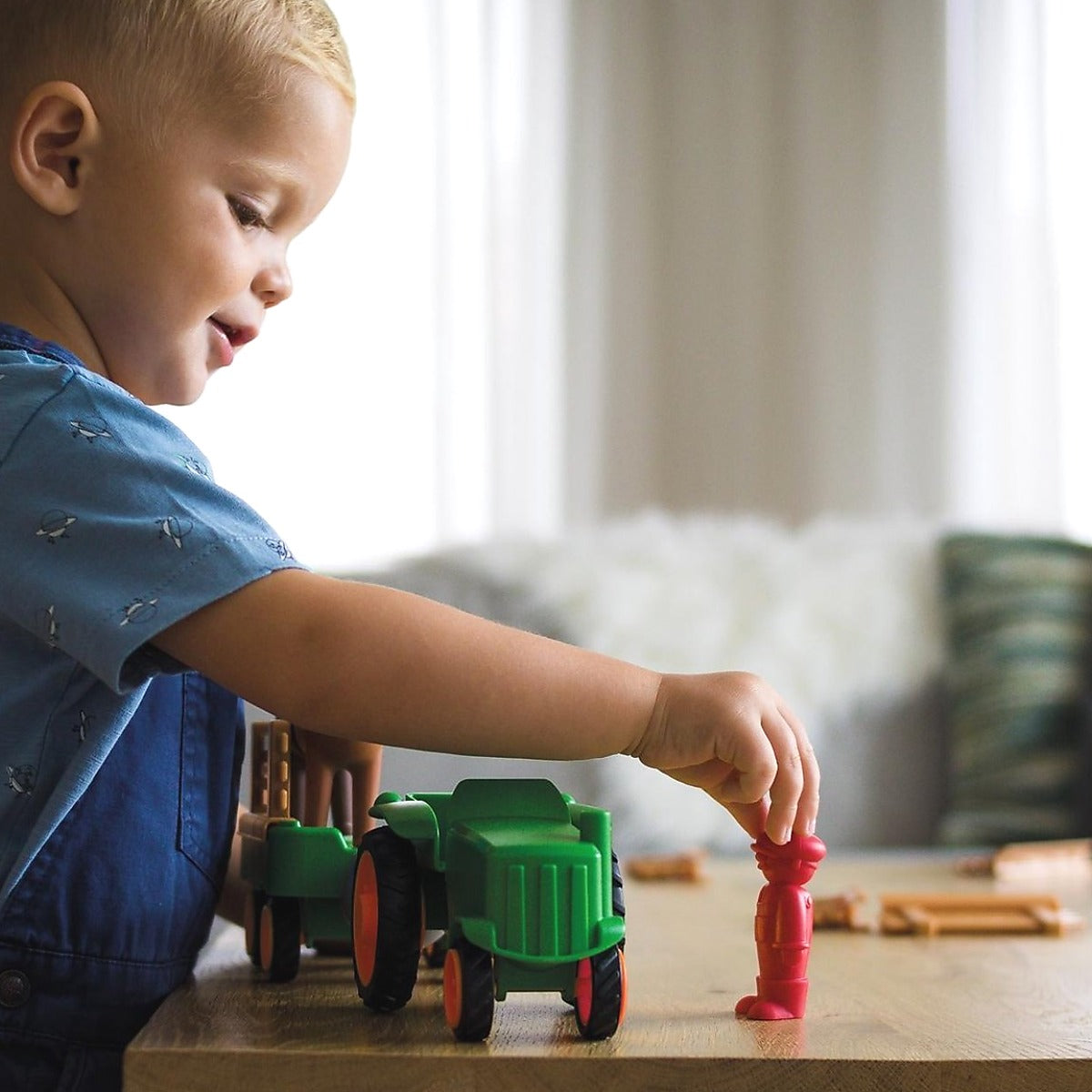 Jongen speelt met SmartMax My First Tractor SMX 222 magnetisch speelgoed op houten tafel in woonkamer