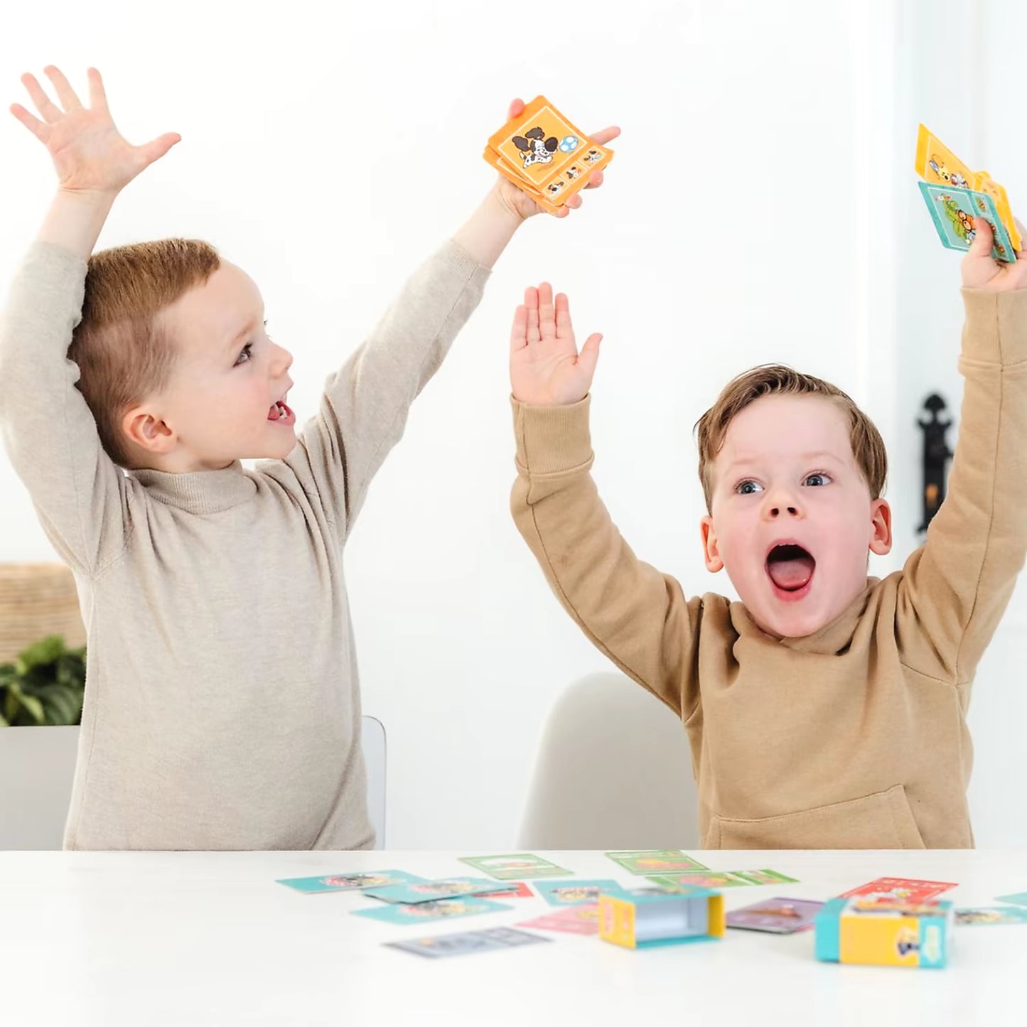 Twee kinderen juichen na winst met Woezel en Pip kwartet, gezellig familiespel vol plezier voor jonge spelers.