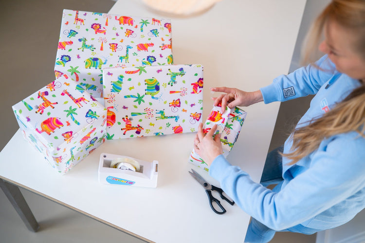 Eigenaar Ruby vouwt kraamcadeau met vrolijk jungleprint papier, persoonlijke cadeauservice Sproutz
