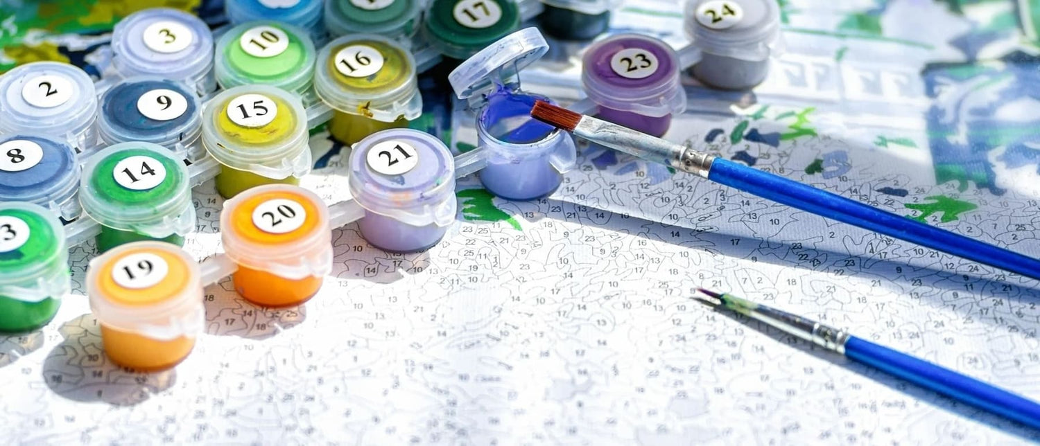 Schilderen op nummer set met genummerde verfpotjes en penselen, bovenaanzicht detail foto voor creatief knutselen.