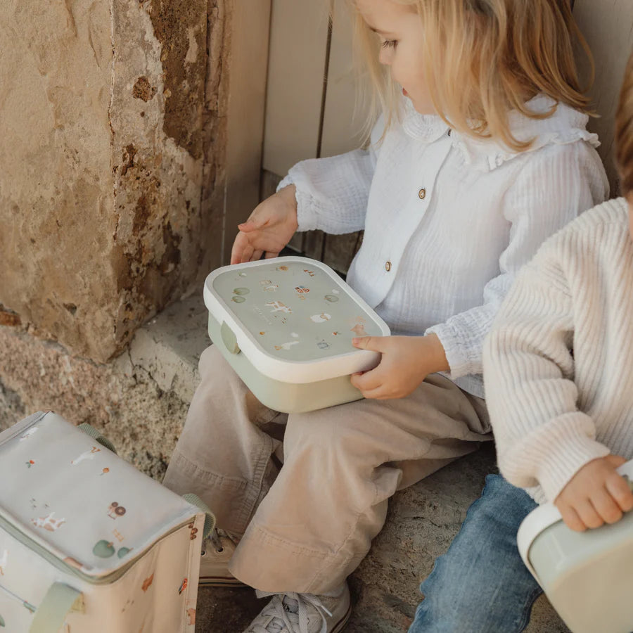 meisje zit op een stoepje met Little Farm lunchbox van Little Dutch om te lunchen