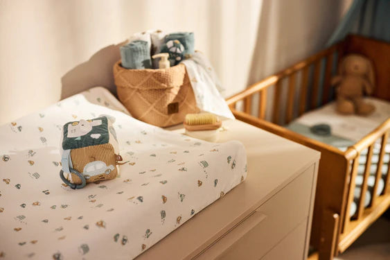 De Jollein activiteitenkubus ligt op een verschoontafel en is het perfecte zachte knuffel speelgoed voor baby’s in hun box.