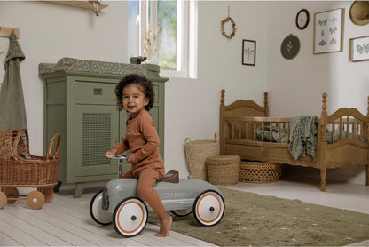 Kind rijdt op Little Dutch auto speelgoed in sfeervolle babykamer met natuurlijke kleuren