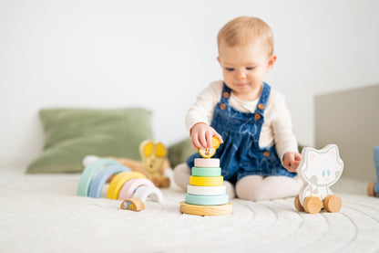 Baby zit met houten stapeltoren educatief speelgoed en Woezel en Pip figuurtje op speelkleed