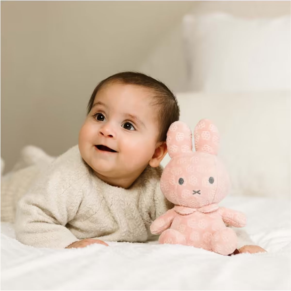 Baby speelt met Nijntje knuffel Pink Flower 20cm, zacht sensorisch speelgoed en perfect kraamcadeau.