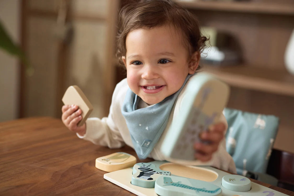 Lachende peuter speelt met houten puzzel Jungle Jambo van Jollein, ideaal als baby speelgoed en motoriektraining.