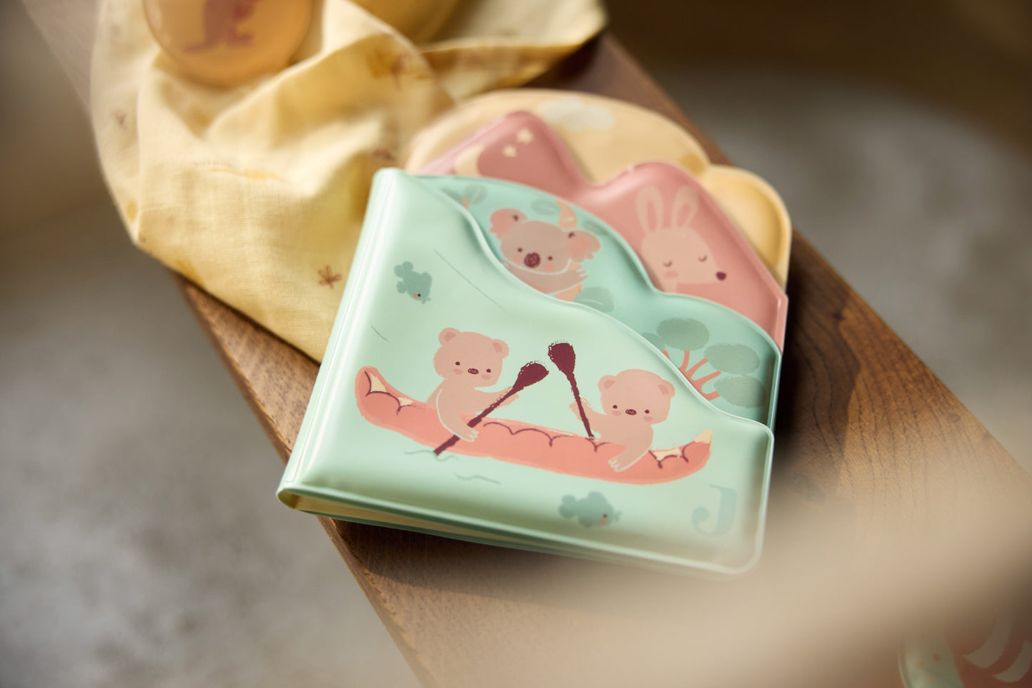 Jollein badspeelgoed badboekje Kangaroots op houten plank met textiel, sfeervolle productfoto voor baby