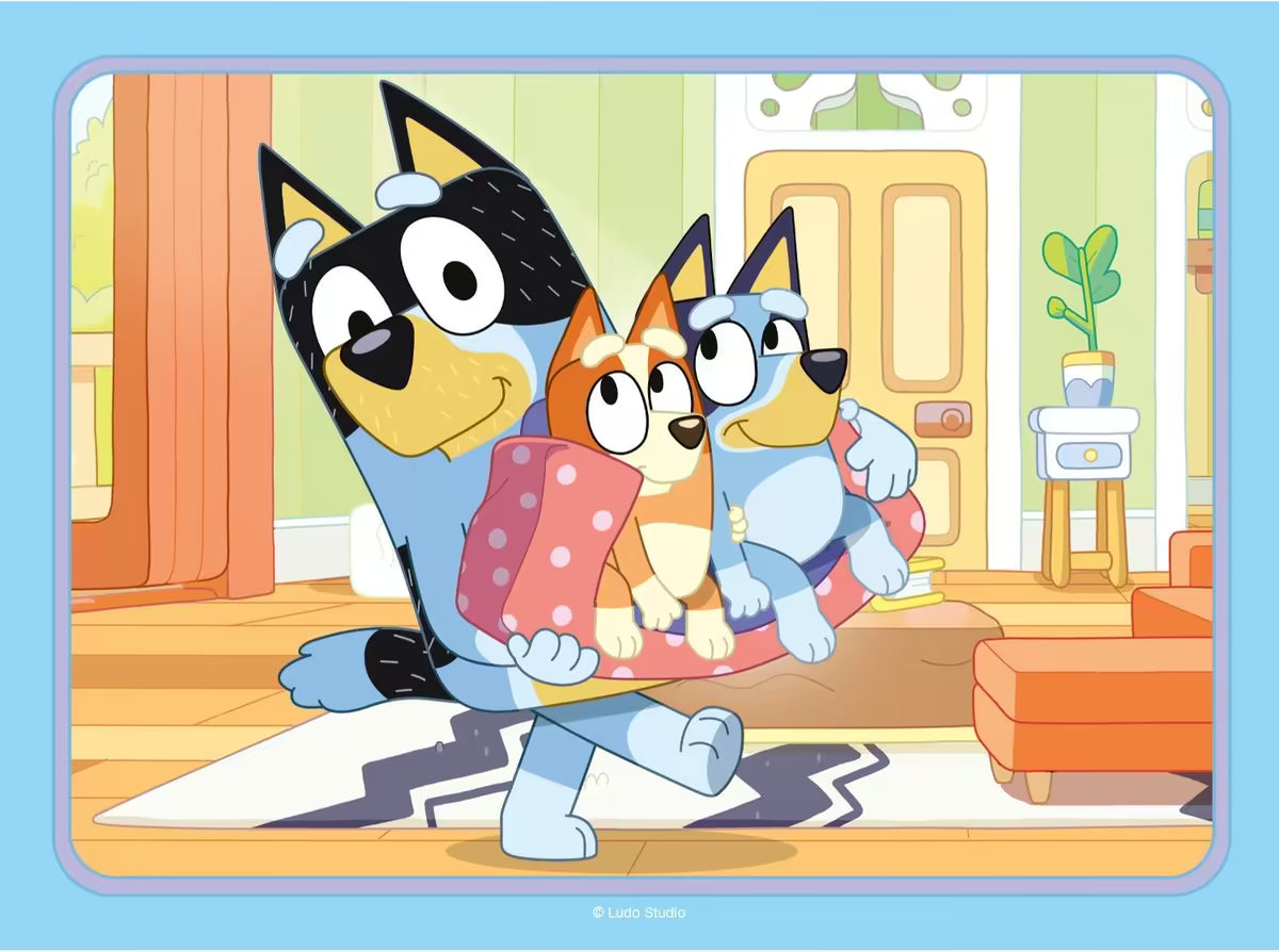 Bandit draagt Bluey en Bingo in de woonkamer, kleurrijke Ravensburger puzzelafbeelding voor peuters en kinderen.