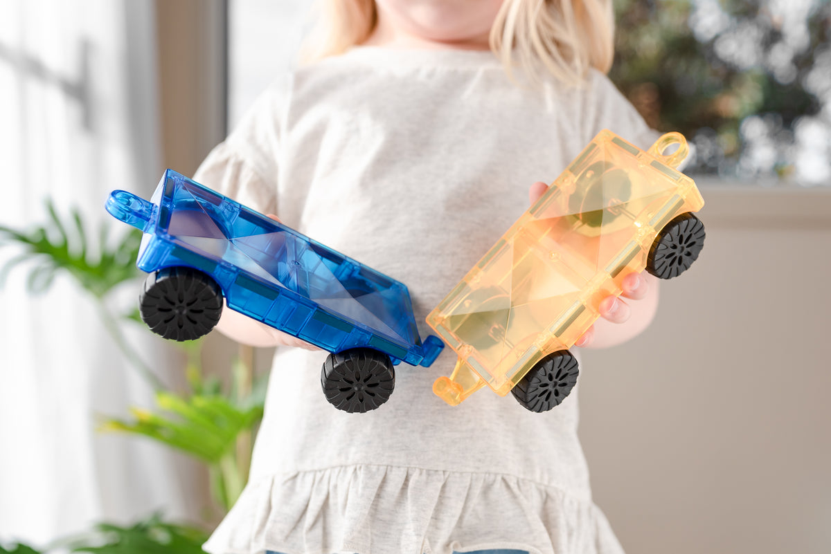 Kind speelt met 2 magnetische autos Connetix Cars Set in transparant blauw en geel kunststof