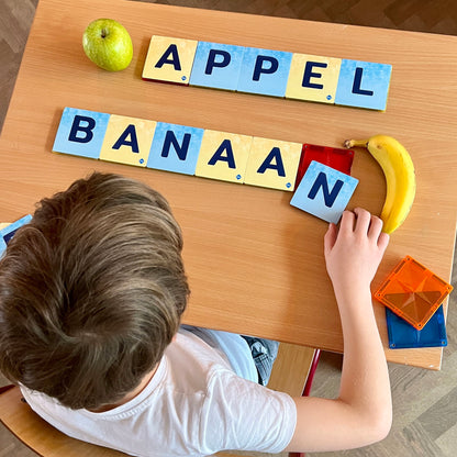 Kind speelt met Coblo magnetisch speelgoed woorden appel banaan leren met letters