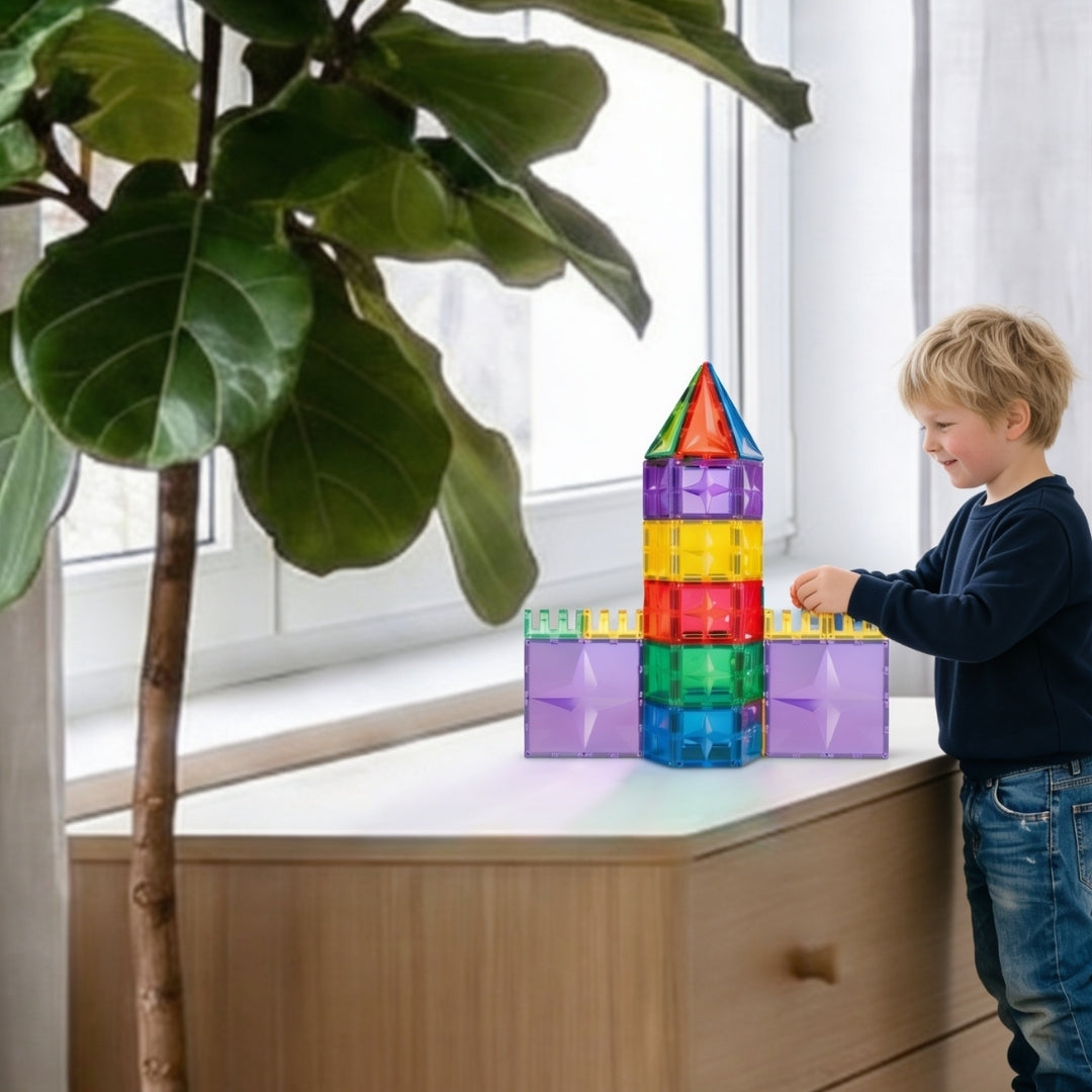 Kind speelt met Coblo magnetic tiles kleurrijke toren, magnetisch bouwen bij raam thuis