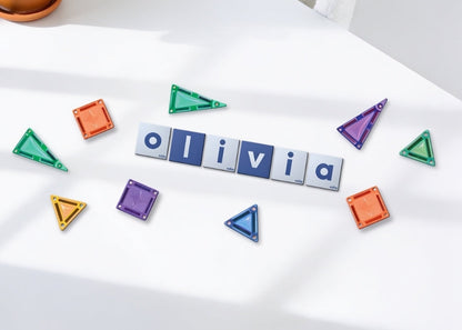 Coblo Mini toppers bovenaanzicht met naam Olivia gelegd op witte tafel met gekleurde magneet tegels