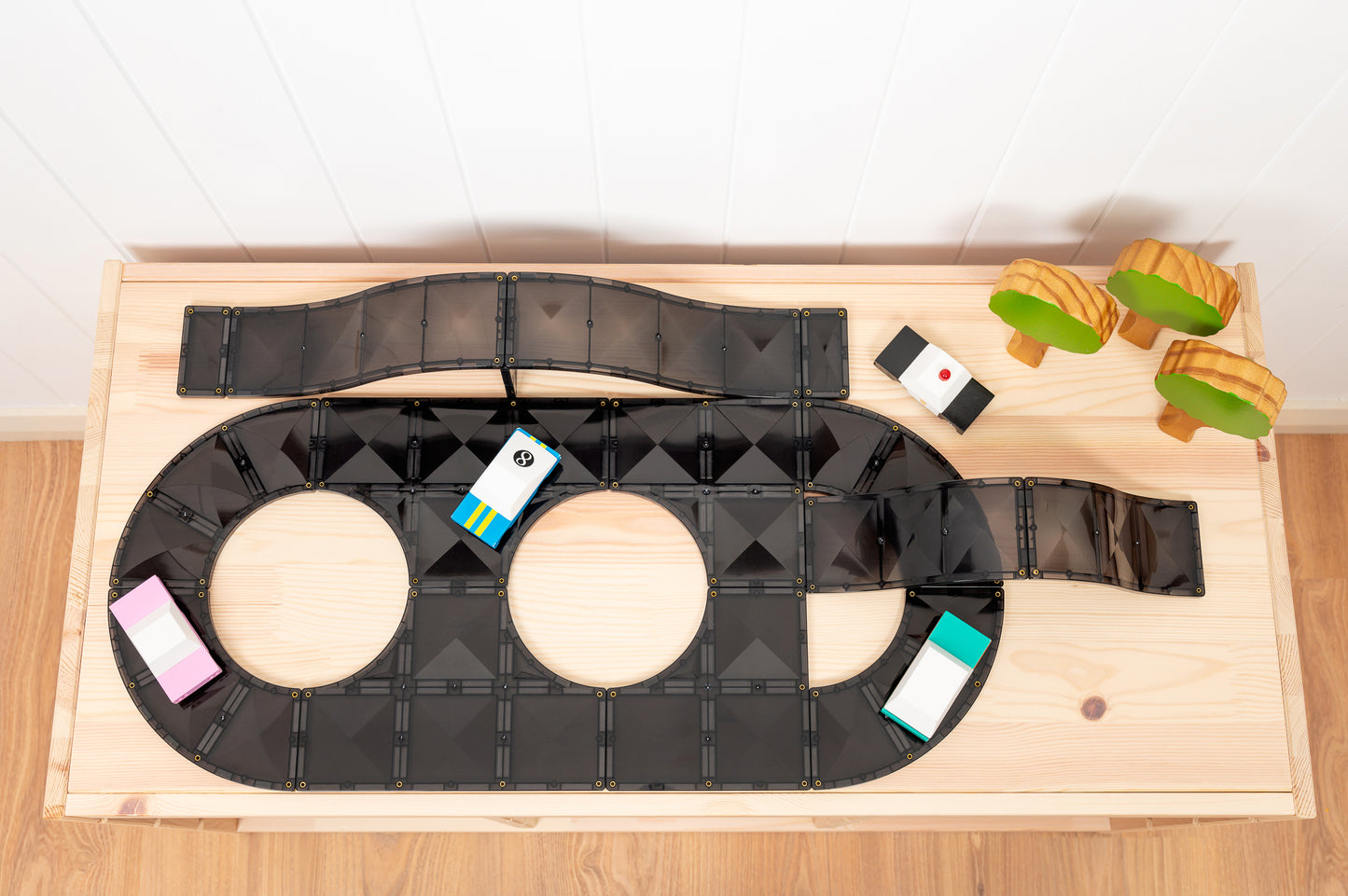 Connetix autobaan configuratie met zwarte tegels, hellingen en gekleurde houten accessoires tafel