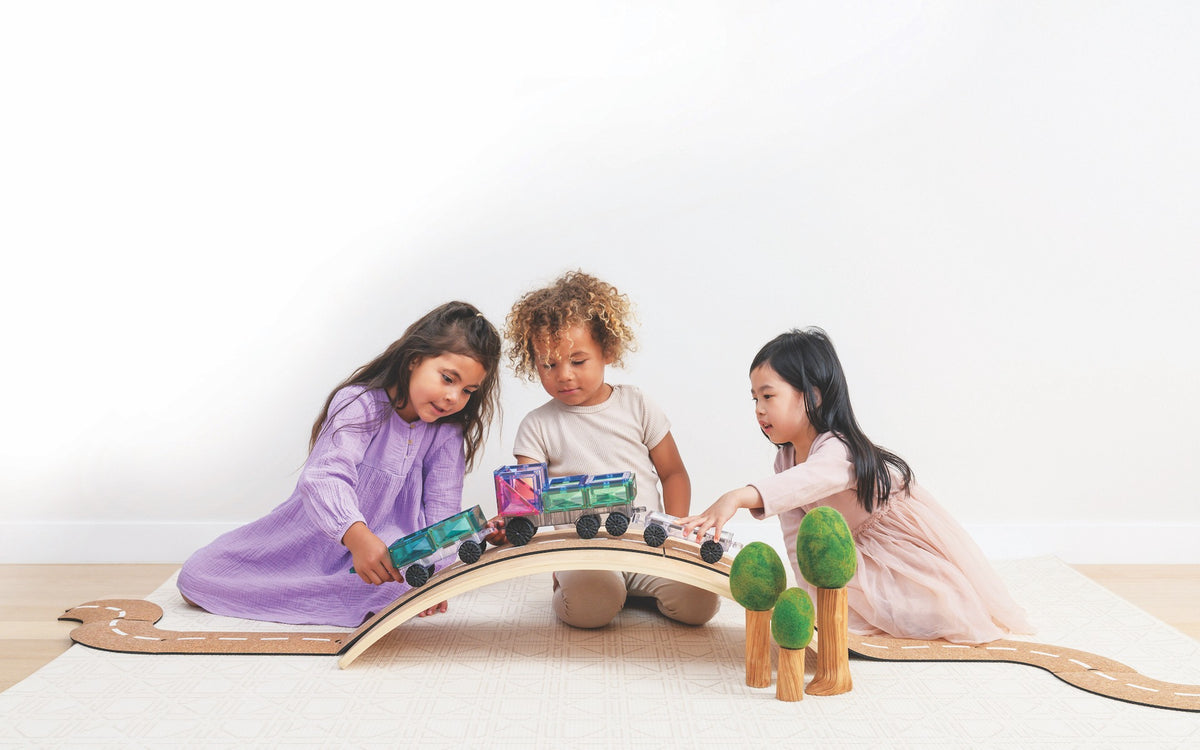 Connetix autobaan met drie kinderen spelend op houten boog pastel magnetisch speelgoed trein