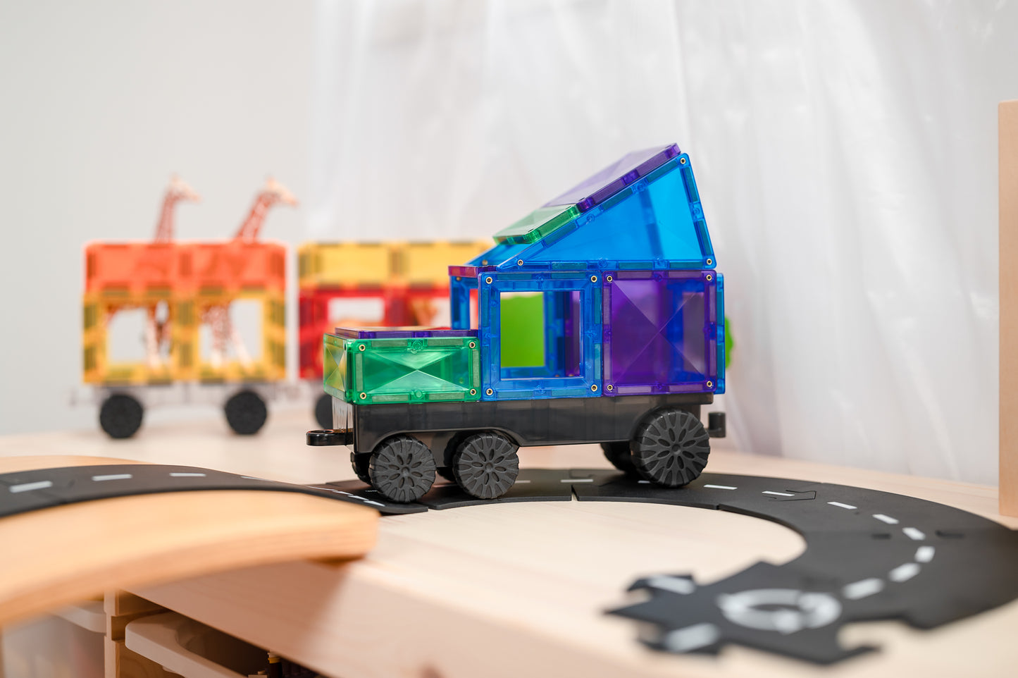 Connetix autobaan met gekleurde magnetische treinen op zwart baanstuk - detail speelsituatie witte tafel