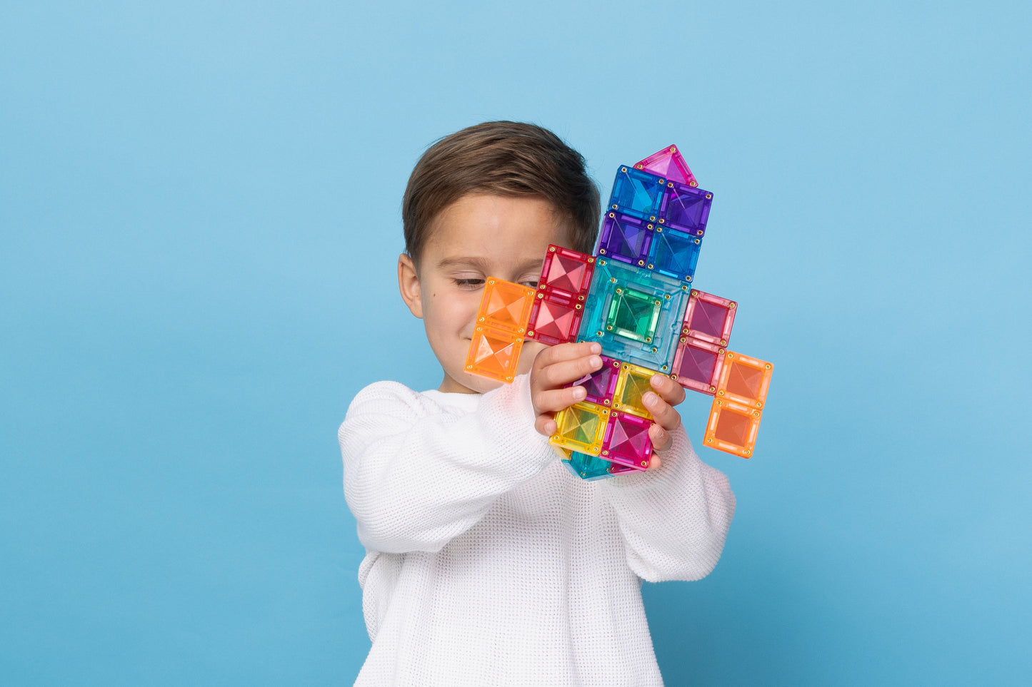 Jongen speelt met Connetix Bright Portal Pack 48pc en bouwt een raket van magnetische tegels