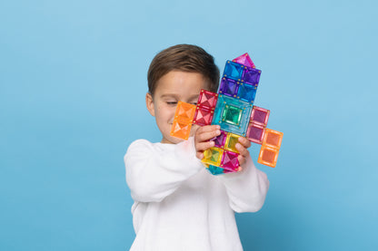 Jongen speelt met Connetix Bright Portal Pack 48pc en bouwt een raket van magnetische tegels