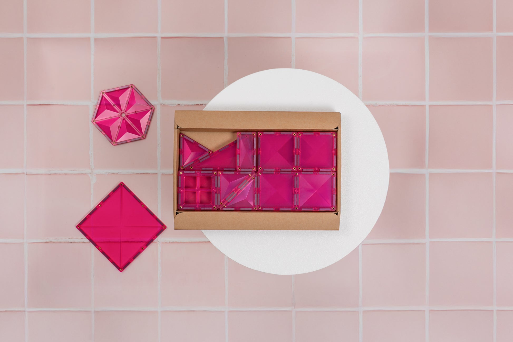 Bovenaanzicht Connetix Charity Pack Pink 20pc open doos met roze magnetische tegels op tegelvloer.