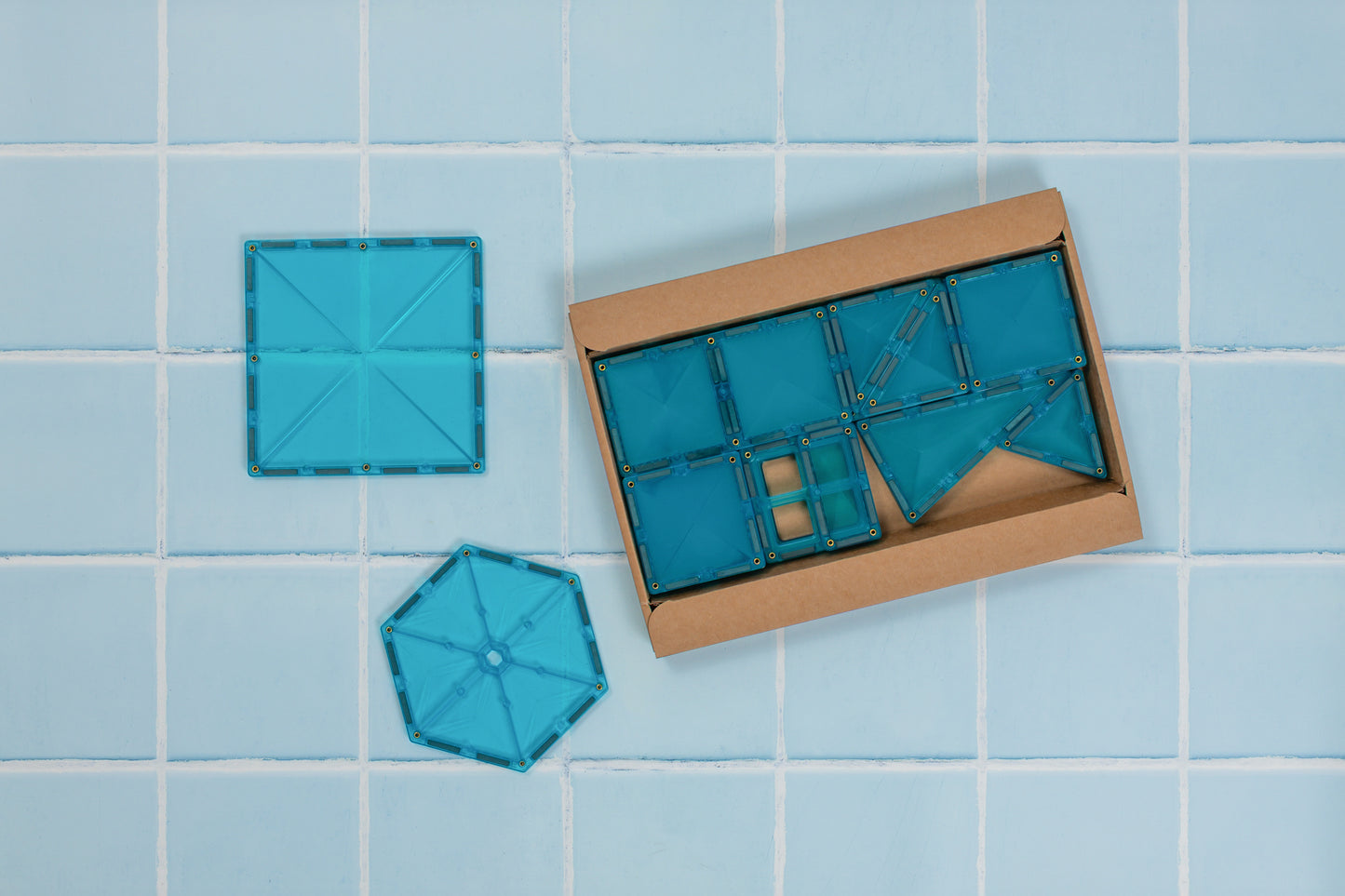 Bovenaanzicht Connetix Charity Pack Teal 20pc – teal magnetische tegels deels uitpakt uit kartonnen verpakking.
