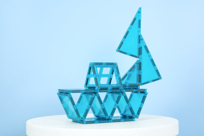 Connetix Charity Pack Teal 20pc – teal connetix tiles gebouwd als zeilboot op witte sokkel, lichtblauwe achtergrond.