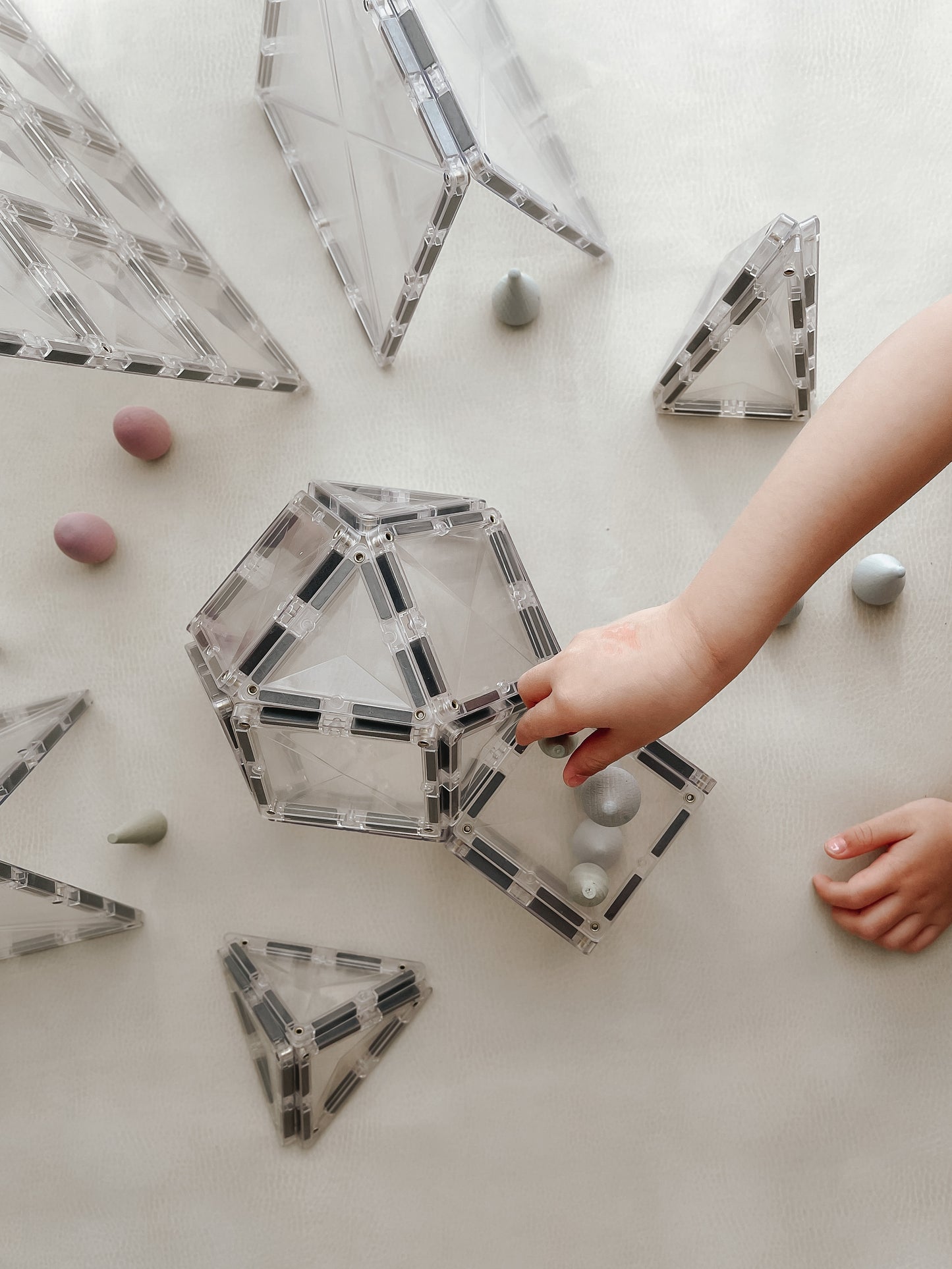 Kind speelt met Connetix Clear Starter Pack 34pc magneten speelgoed en bouwt transparante vormen