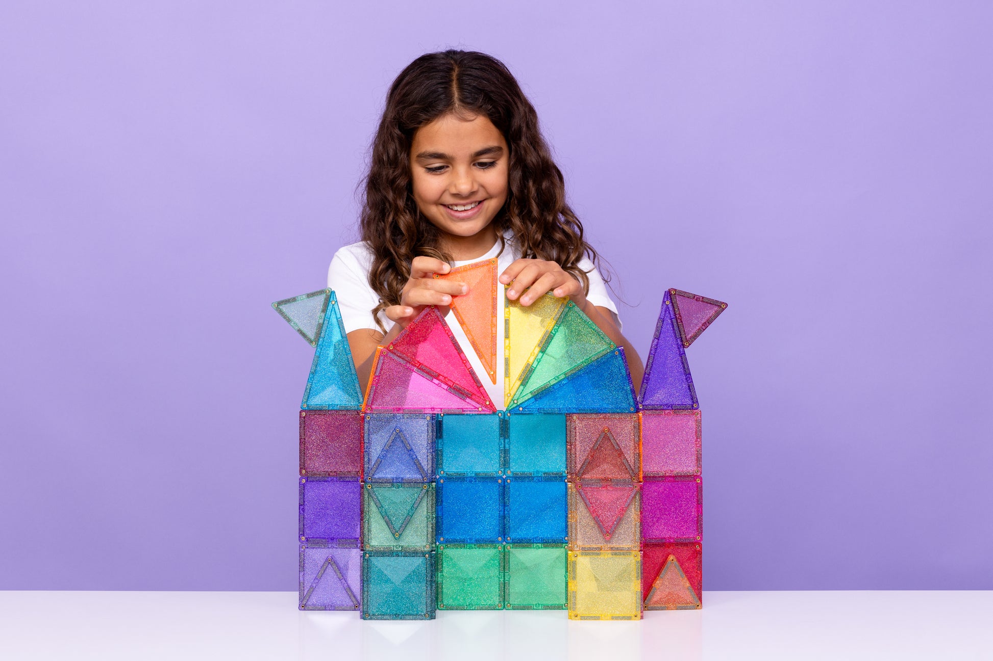 Meisje speelt met Connetix Glitter Castle Pack 48pc en bouwt een kasteel van magneet speelgoed