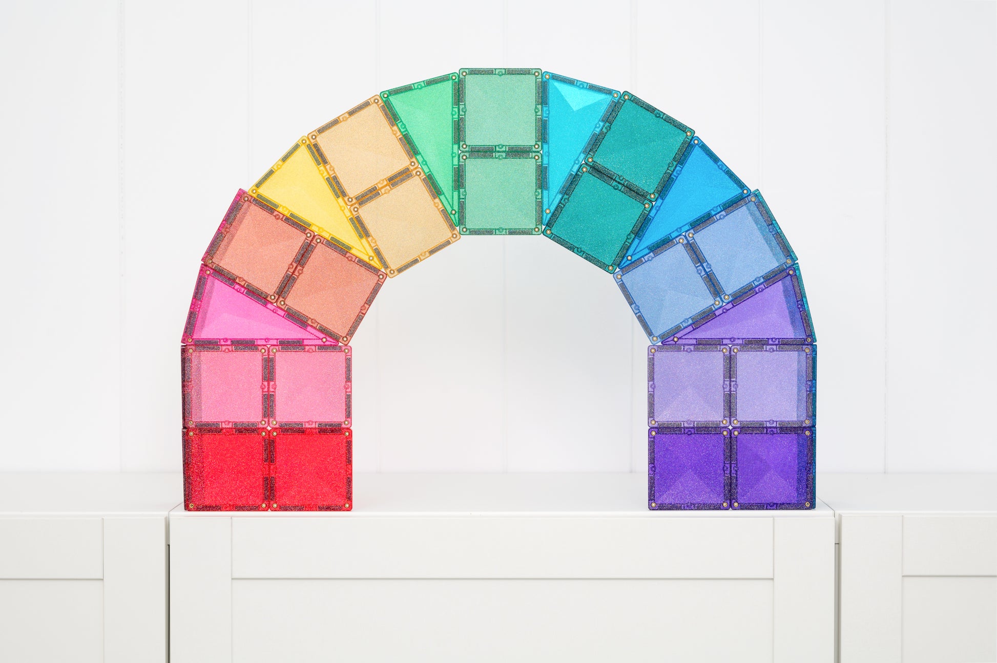 Regenboog gebouwd met Connetix Glitter Castle Pack 48pc glitter magneet tegels op witte kast