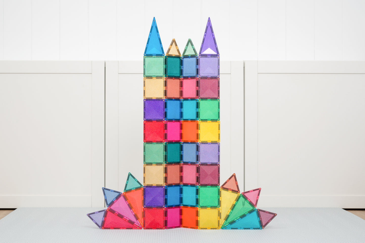 Hoge toren met driehoeken gebouwd met Connetix Glitter Castle Pack 48pc connetix tiles op speelmat