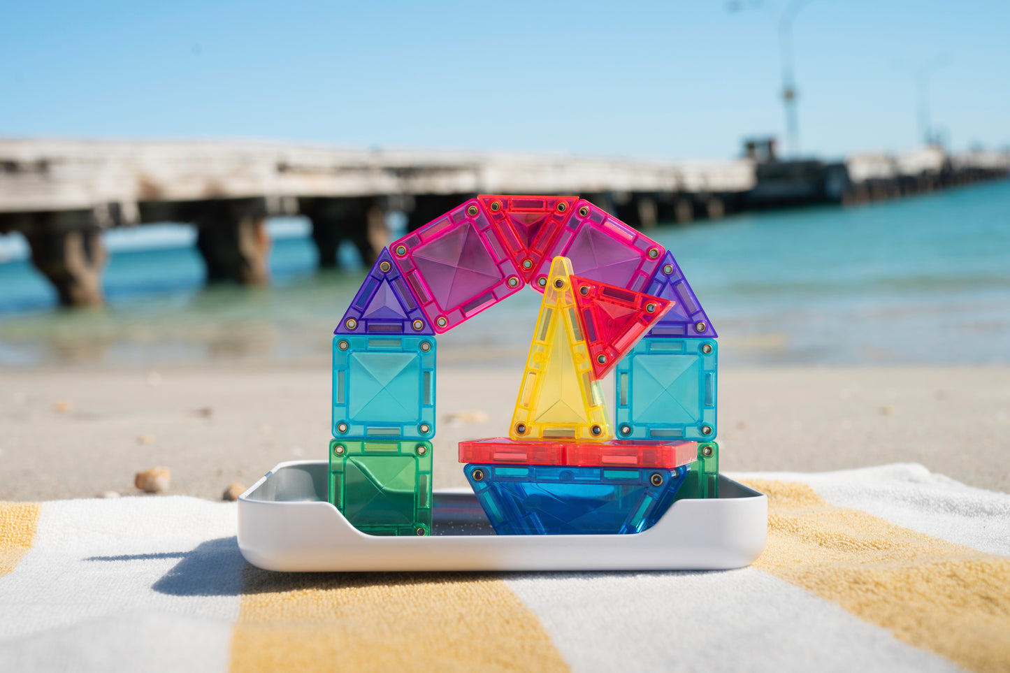 Connetix travel mini pack zeilboot gebouwd met magnetisch speelgoed op strandhanddoek bij zee