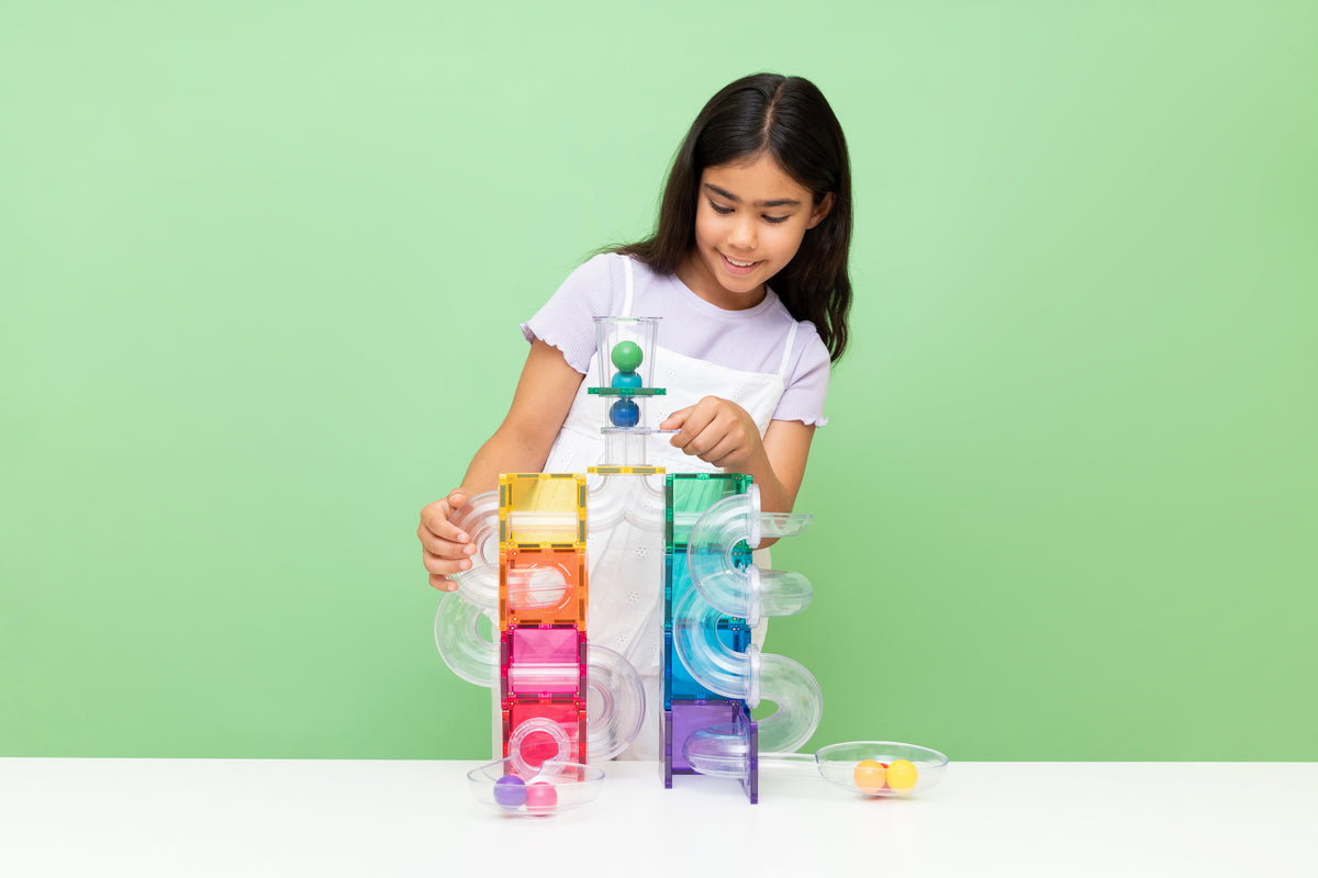 Kind speelt met Connetix magnetisch speelgoed knikkerbaan rainbow tegels en gekleurde knikkers