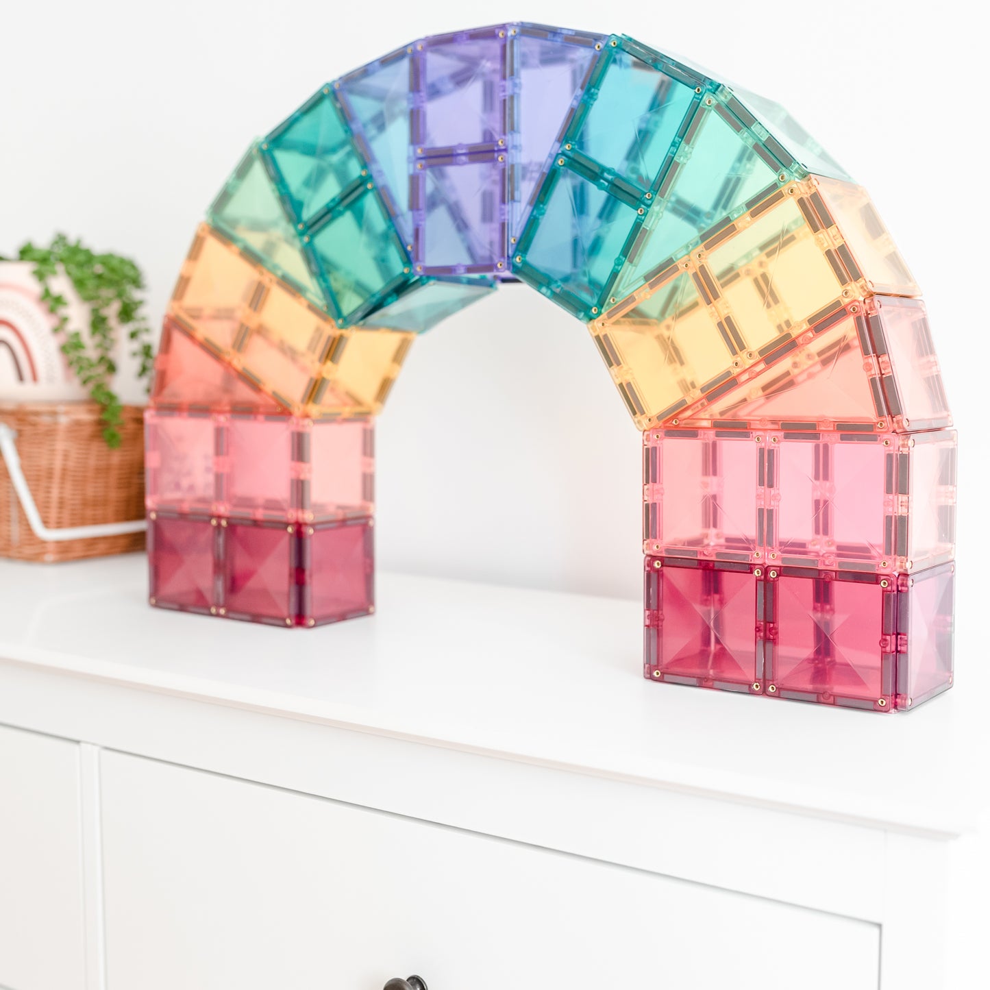 Connetix magnetische tegels pastel regenboogboog constructie op wit dressoir met plantje decoratie