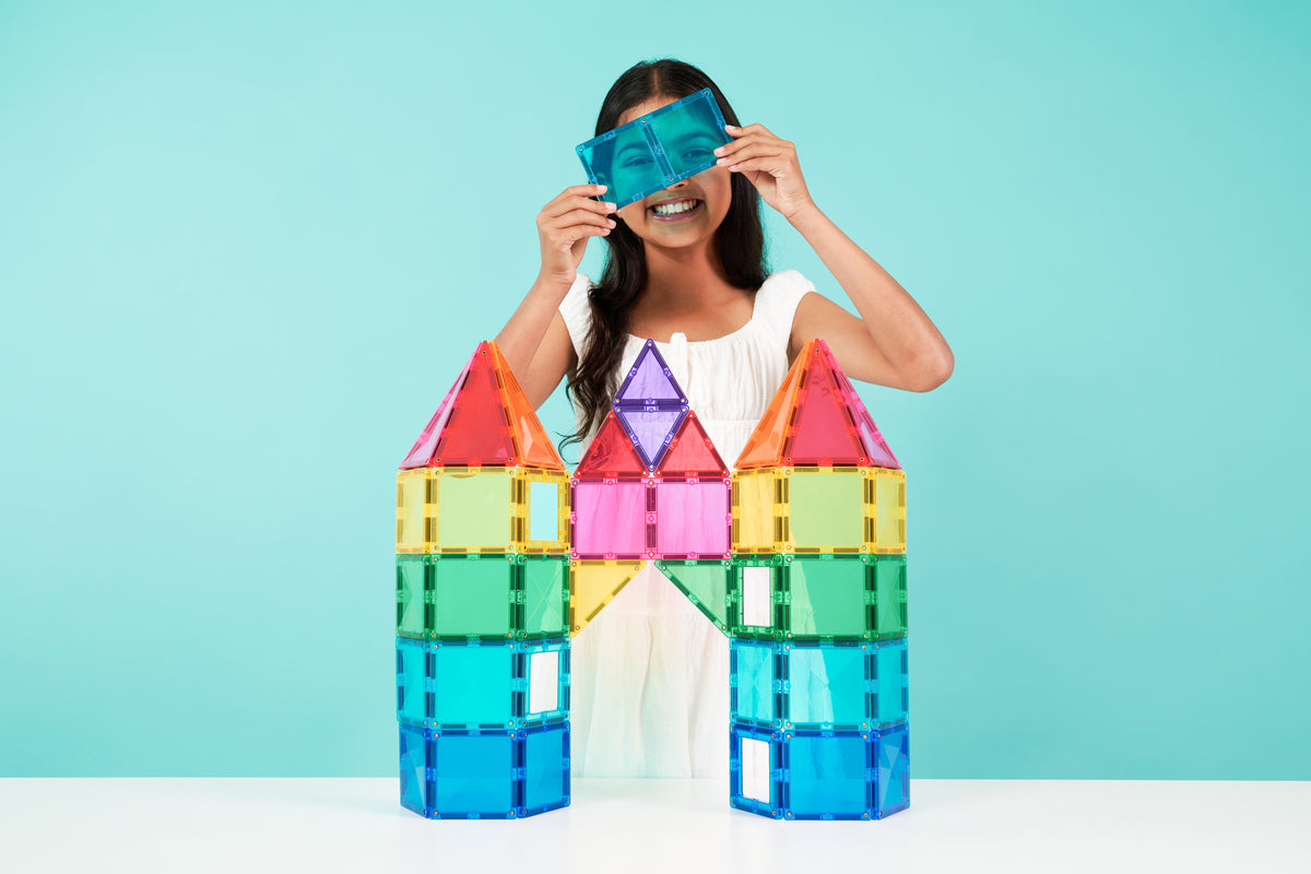 Kind houdt blauwe Connetix magnetische tegel vast bij kasteel van Bright Creative Pack 104