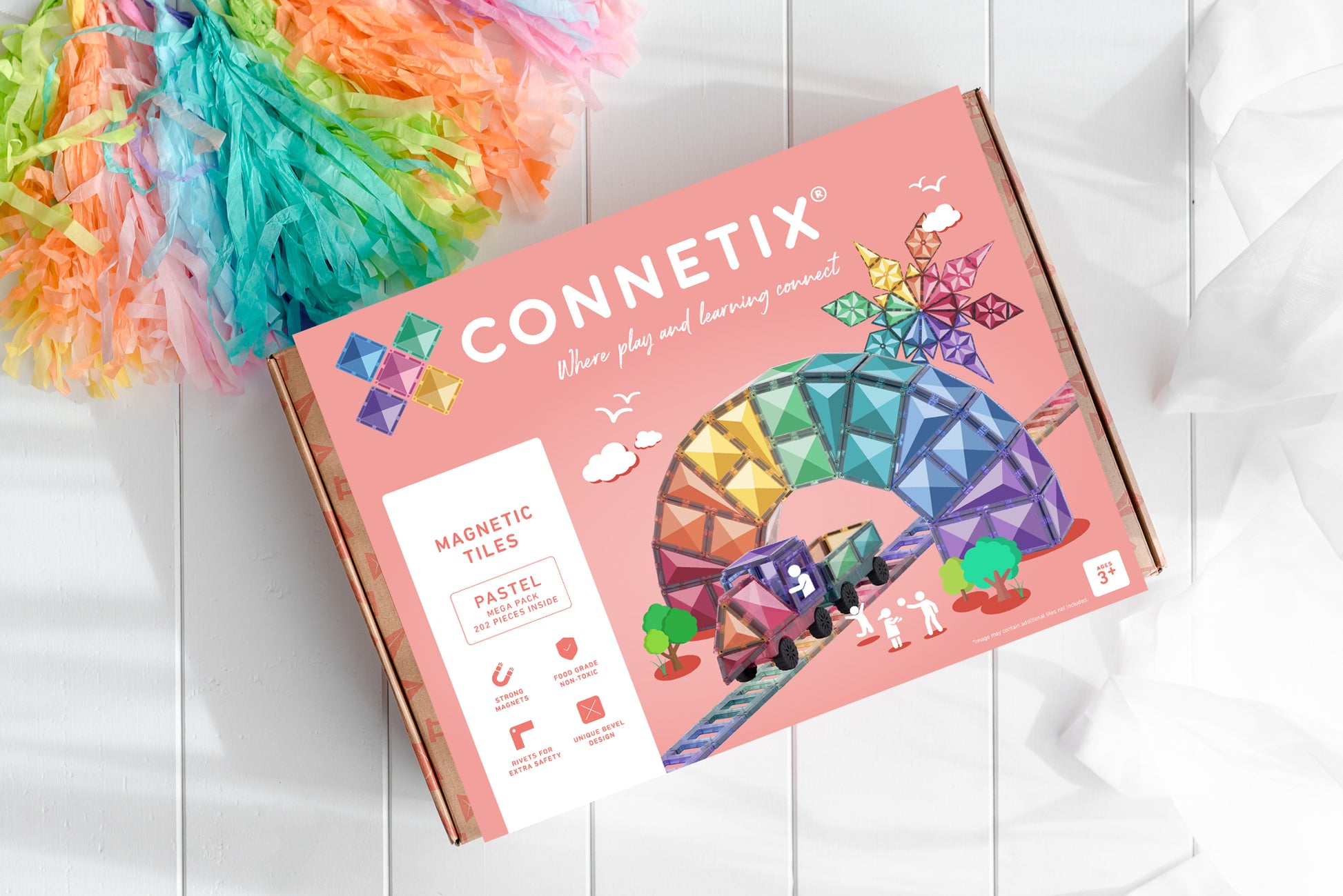 Connetix speelgoed verpakking bovenaanzicht met roze doos en kleurrijke slinger op witte ondergrond