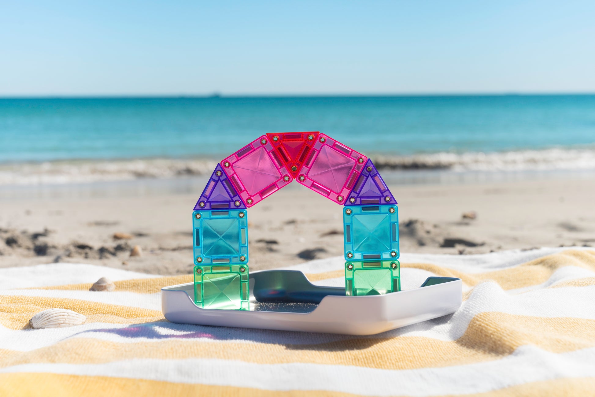 Connetix travel mini pack boog constructie met kleurrijke magnetische mini tegels op strand