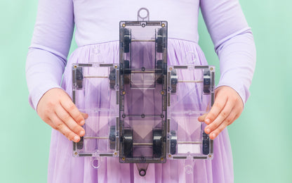 Connetix Pastel magnetische tegels bovenaanzicht paarse wagon vastgehouden door kind groene achtergrond