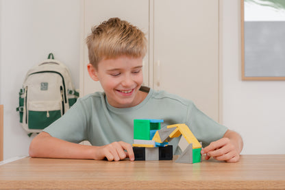 Connetix PRO magnetisch speelgoed: kind bouwt kleurrijk voertuig met gele en groene magneet tegels