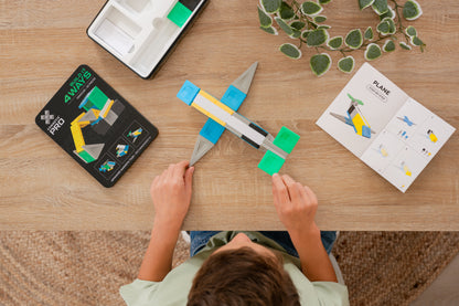 Connetix PRO Build It 4 Ways: bovenaanzicht kind bouwt vliegtuig met instructieboekje en magneet speelgoed