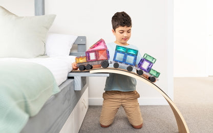 Connetix racebaan jongen spelend met pastel magneet speelgoed trein op houten boog slaapkamer setting