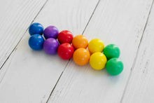 Connetix Rainbow Ball Pack 12 houten knikkers in regenboogkleuren op witte houten achtergrond