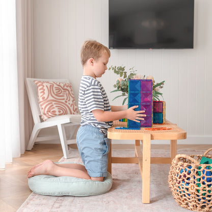 Jongen bouwt toren met Connetix Rainbow magnetisch speelgoed, rechthoekige tegels in regenboogkleuren