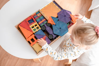 Bovenaanzicht: peuter pakt Connetix Rainbow Mega Pack 212pc connetix speelgoed uit houten bewaarbox op witte tafel